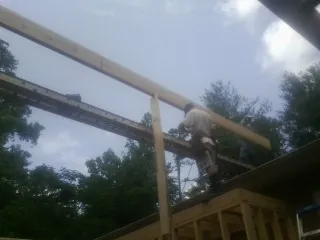 Carpenter setting a ridge beam over a new addition frame — Ice Dam Removal by Roofing Brothers in Harwich Port