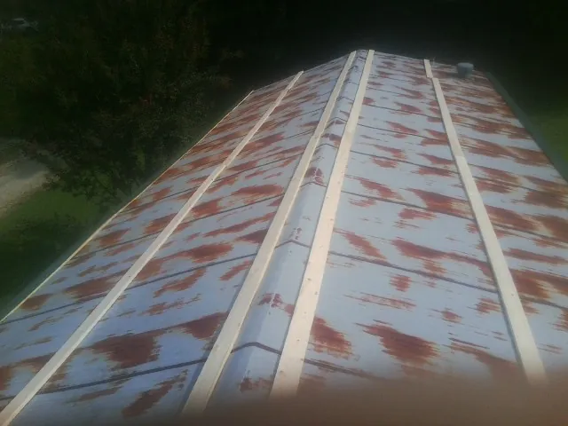 Rusted metal roof panels with new wood purlins before replacement — Storm Damage Roof Repair in Harwich Port by Roofing Brothers