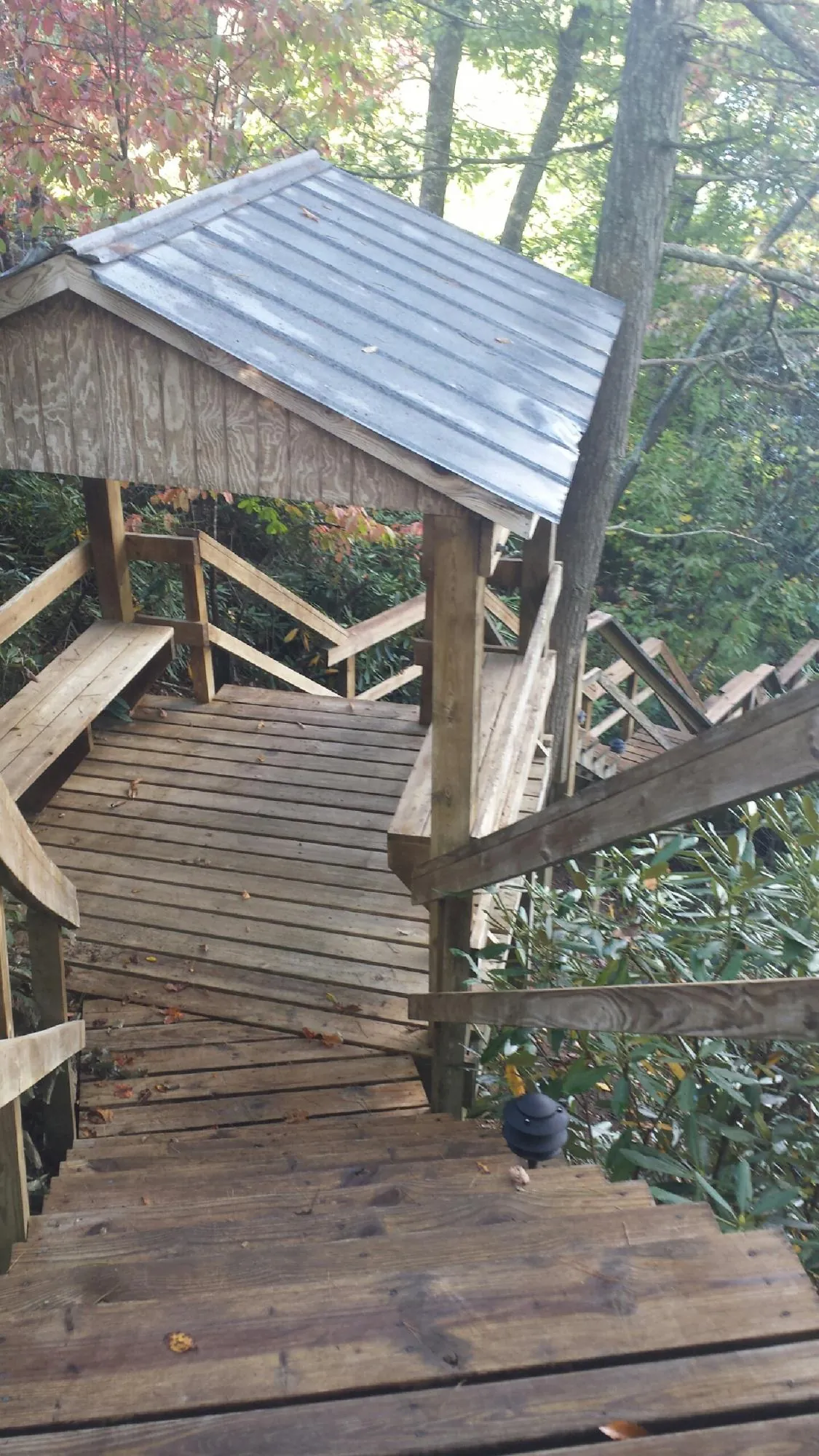 Metal roofed shelter over wooden steps on a wooded walkway — Skylight Repair & Installation work by our crew in Harwich Port