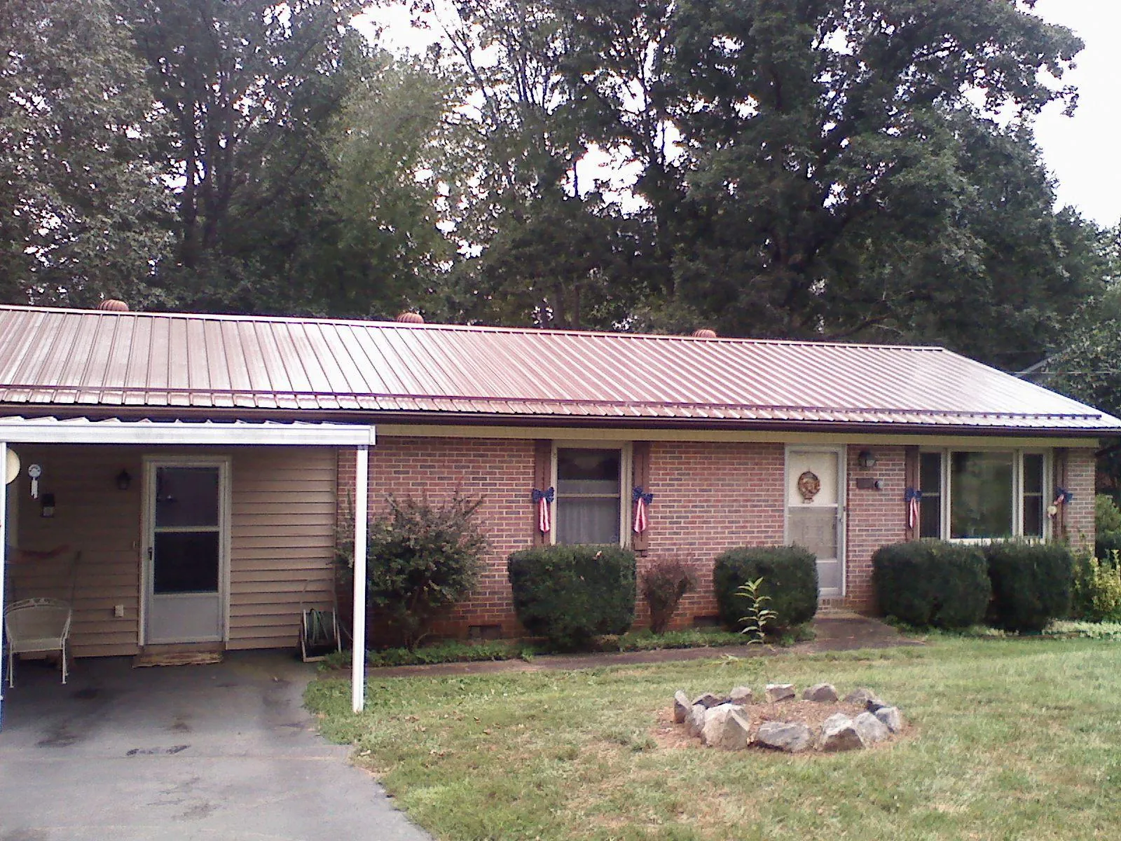Bronze metal roof and carport on a brick ranch home — Roof Repair work by our crew in Harwich Port